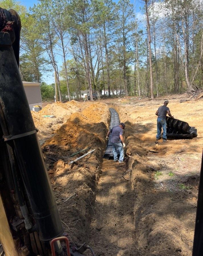 Crew installing drain field pipe